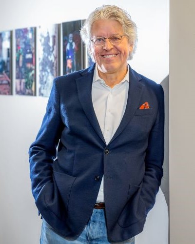 Mark Kosieradzki smiling and leaning against a wall